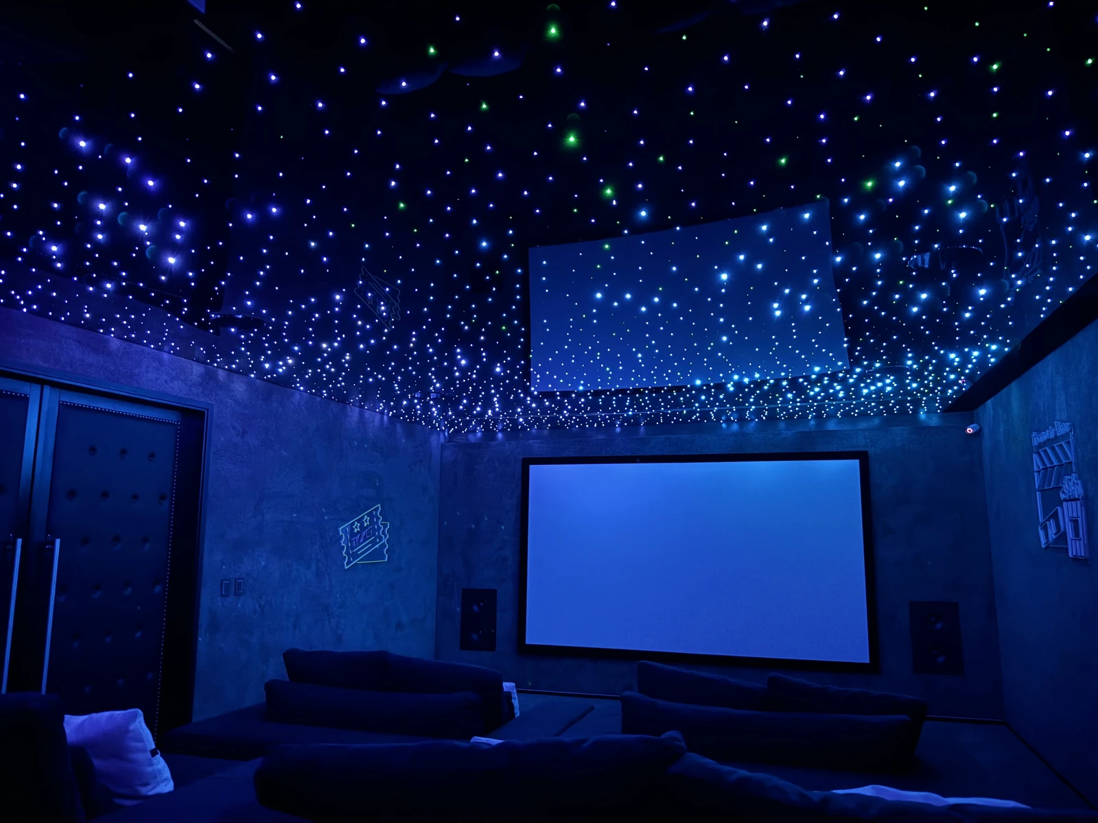 Vista hacia la pantalla de la misma sala con sofás y estrellas azules